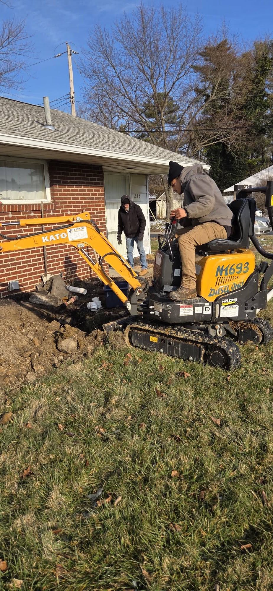 Mini-excavator on a sewer line and property job